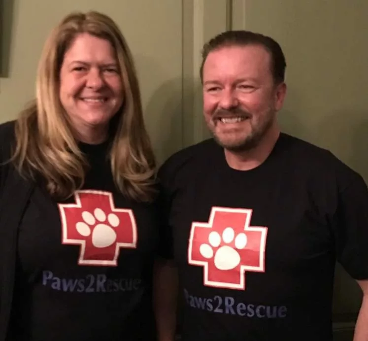 A photo of comedian Ricky Gervais and Paws2Rescue founder Alison Standbridge, both pictured wearing t-shirts with the Paws2Rescue logo printed on the front