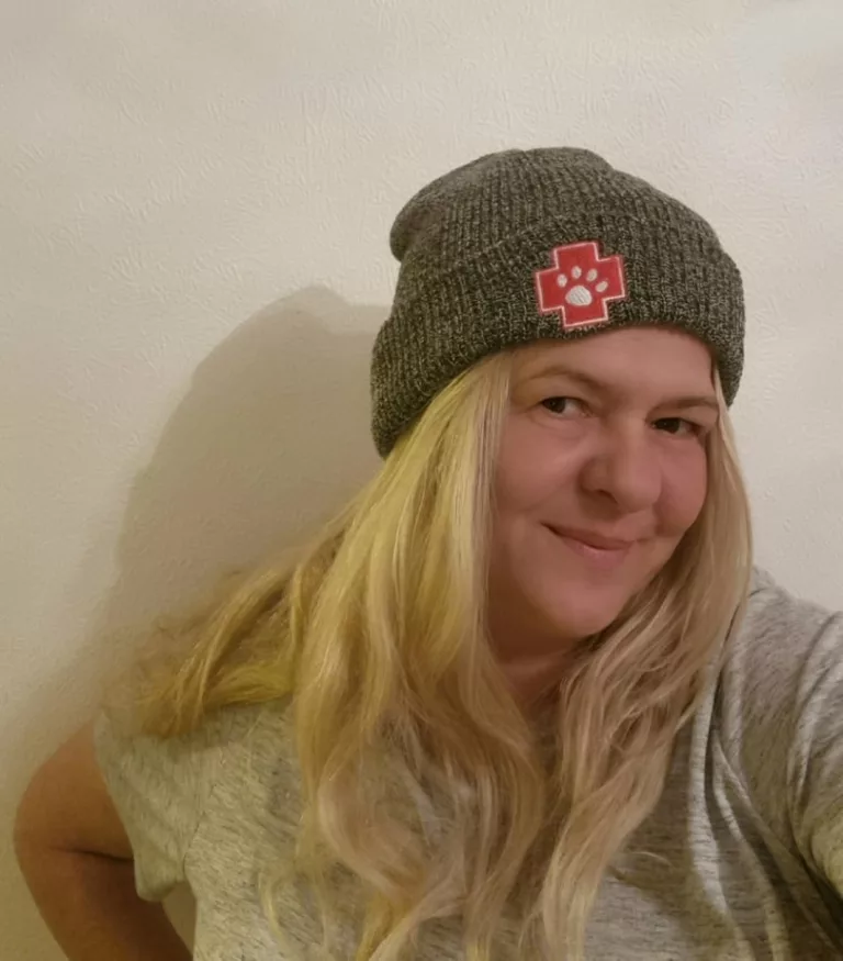A photo of Paws2Rescue founder Alison Standbridge wearing a beanie hat with a red Paws2Rescue logo on