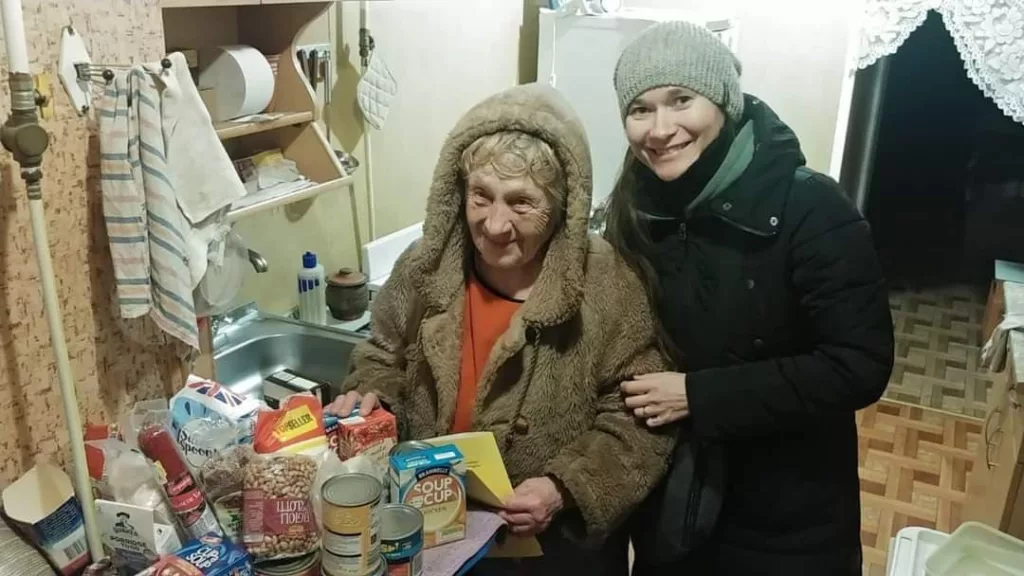 A lady in Ukraine in her home receiving our food donations. 